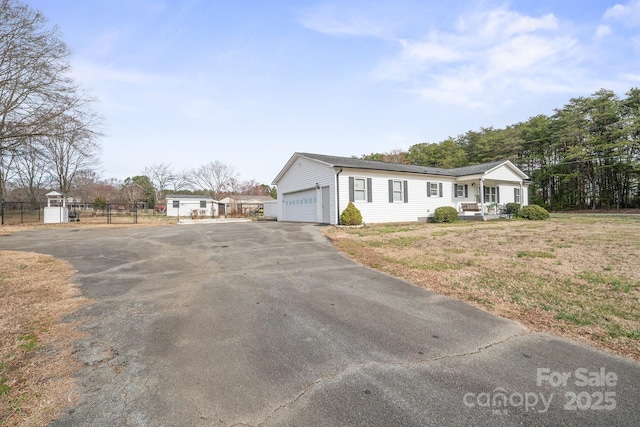 view of front of home featuring aphalt driveway and fence