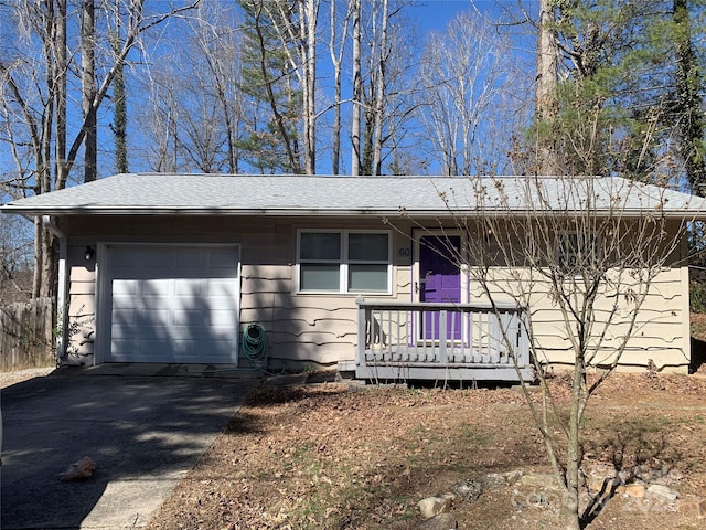 view of front of home featuring driveway, a shingled roof, and an attached garage