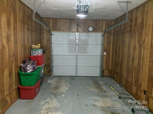 garage featuring wooden walls and a garage door opener