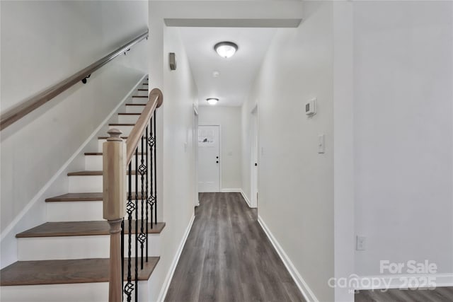 staircase with baseboards and wood finished floors