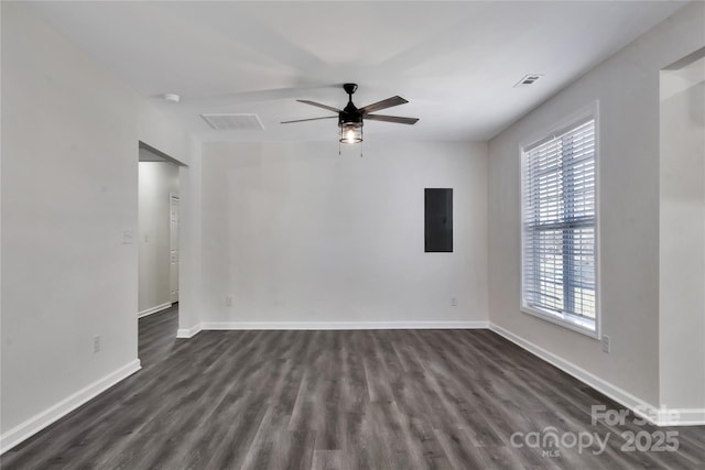 empty room featuring a ceiling fan, dark wood-style flooring, visible vents, and baseboards