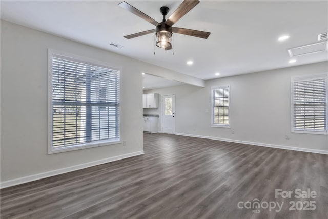 unfurnished living room featuring baseboards, visible vents, dark wood-style flooring, and recessed lighting