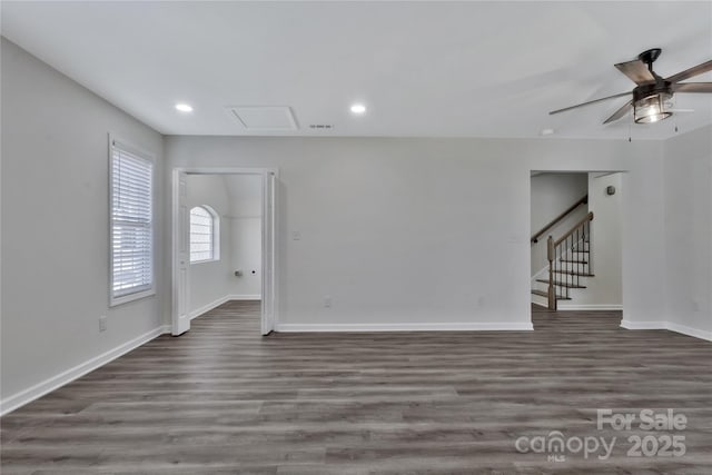 unfurnished room with recessed lighting, attic access, wood finished floors, baseboards, and stairs