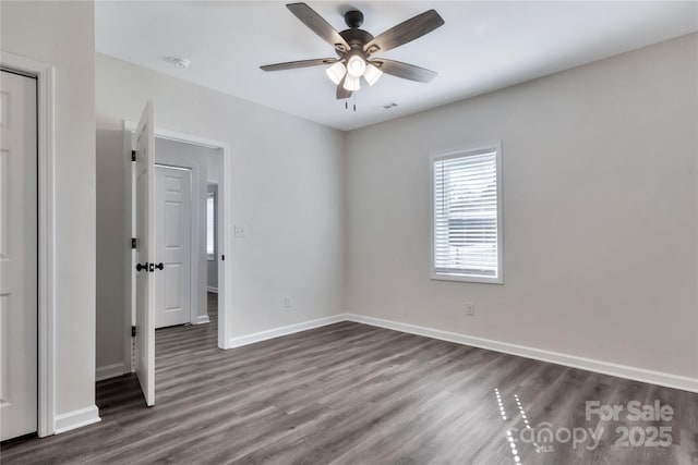 unfurnished bedroom with dark wood-style floors, visible vents, ceiling fan, and baseboards