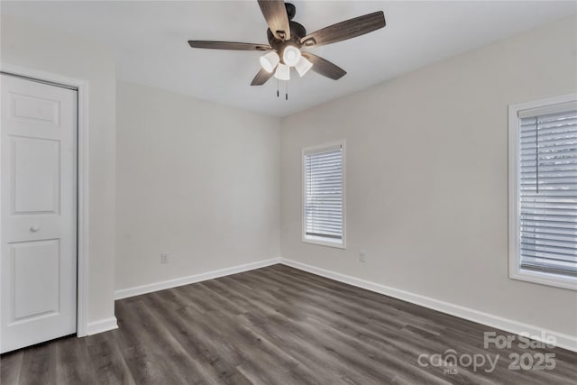 unfurnished room featuring a ceiling fan, baseboards, and dark wood-type flooring