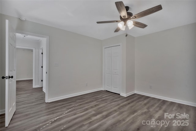 unfurnished bedroom featuring ceiling fan, baseboards, dark wood finished floors, and a closet