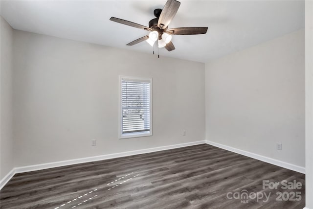 empty room featuring a ceiling fan, dark wood-style flooring, and baseboards