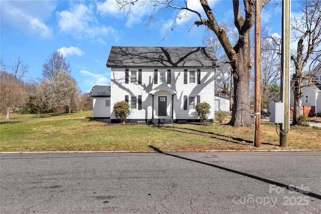 colonial home featuring a front lawn