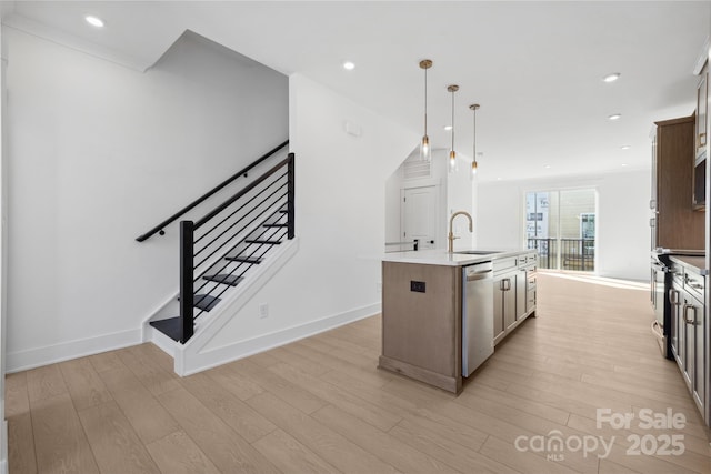 kitchen featuring light wood finished floors, range with electric cooktop, dishwasher, an island with sink, and a sink