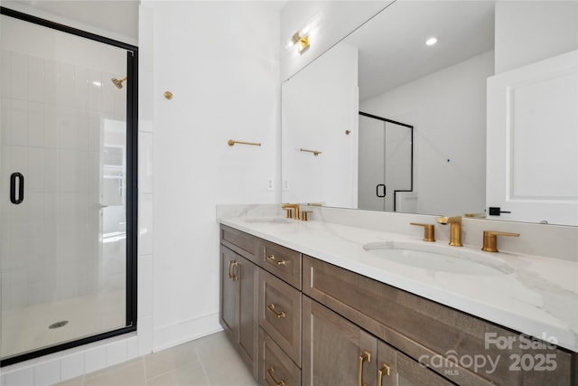 bathroom featuring double vanity, a stall shower, a sink, and tile patterned floors