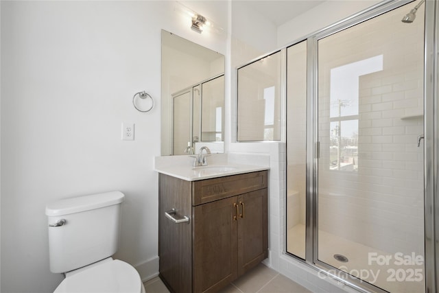 bathroom featuring a stall shower, tile patterned flooring, vanity, and toilet