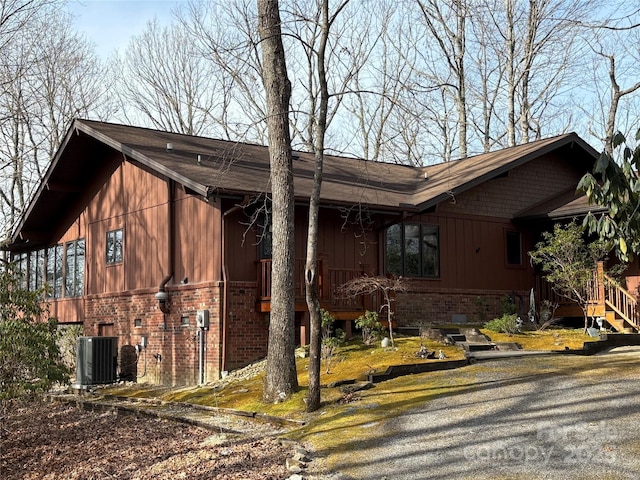 view of home's exterior with cooling unit and brick siding