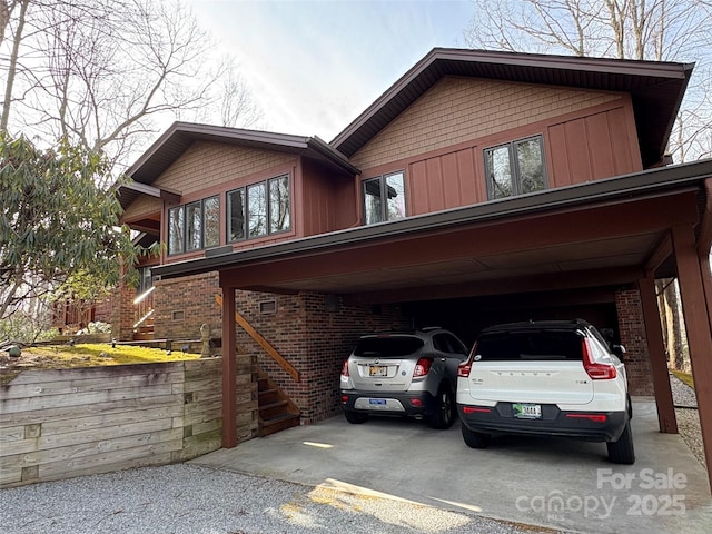 exterior space with stairs, a carport, and driveway