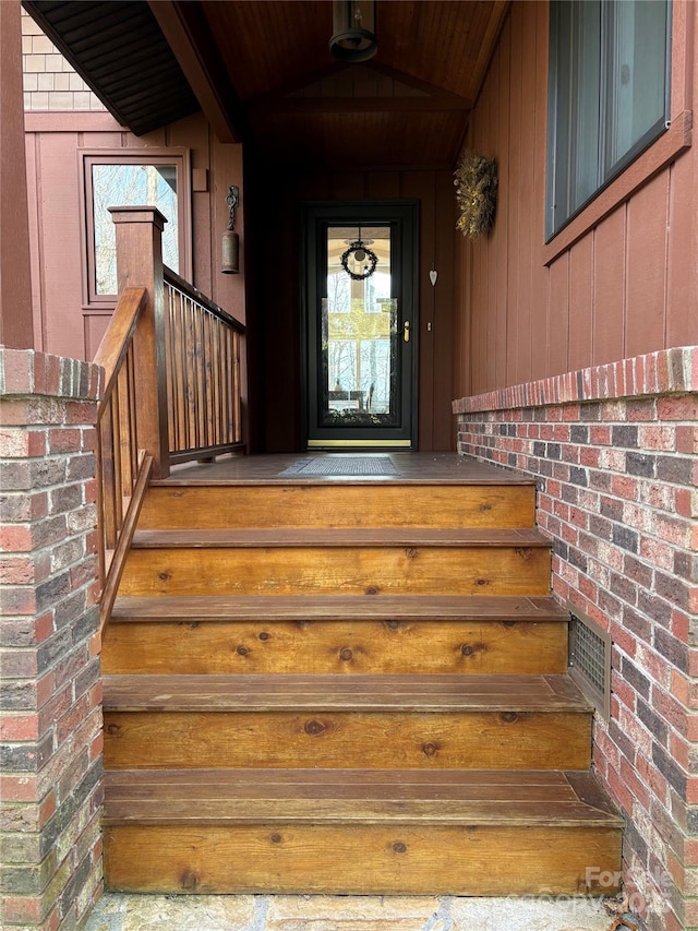 entrance to property featuring brick siding