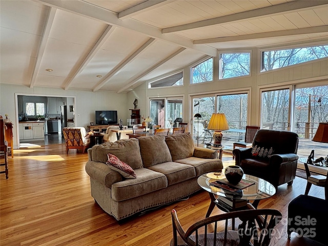 living room with lofted ceiling with beams and wood finished floors