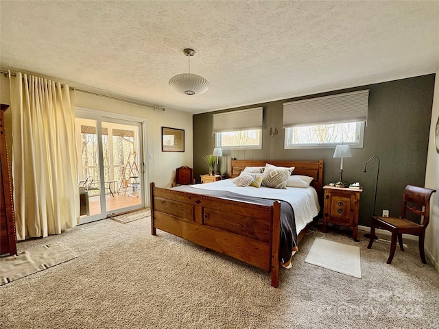 carpeted bedroom featuring access to exterior and a textured ceiling