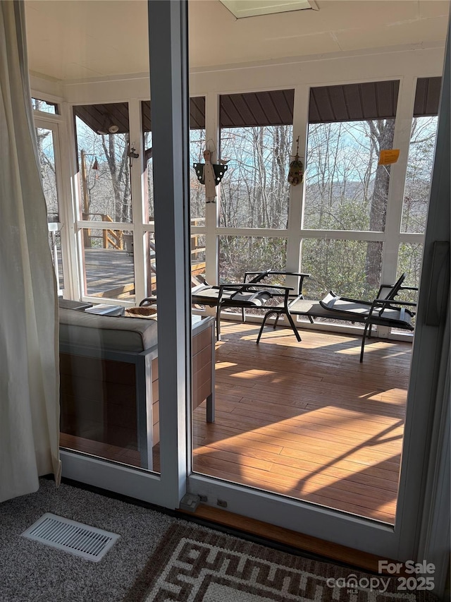 doorway to outside with wood-type flooring and a healthy amount of sunlight