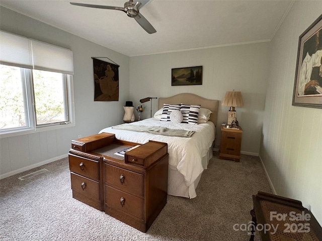 carpeted bedroom with ceiling fan, crown molding, visible vents, and baseboards