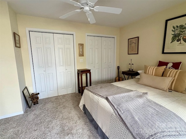 bedroom with ceiling fan, multiple closets, and carpet flooring