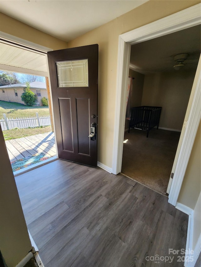 foyer with baseboards and wood finished floors