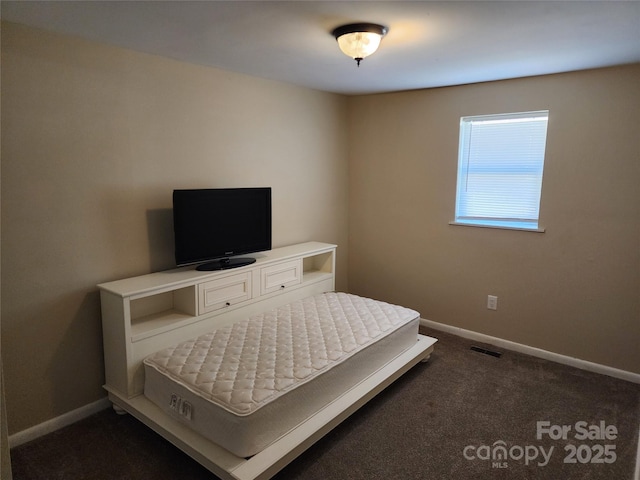 bedroom featuring dark carpet, visible vents, and baseboards