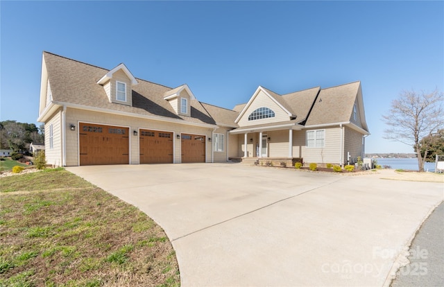 view of front of house with a porch, an attached garage, concrete driveway, and a shingled roof