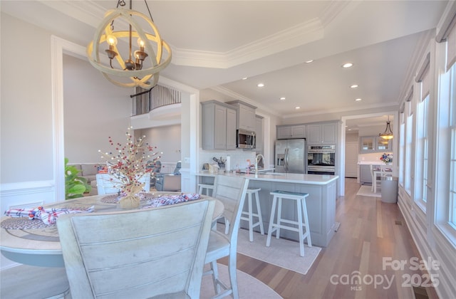 dining space featuring an inviting chandelier, recessed lighting, light wood-type flooring, and ornamental molding