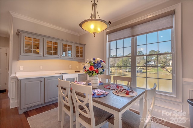 dining area featuring wood finished floors and ornamental molding