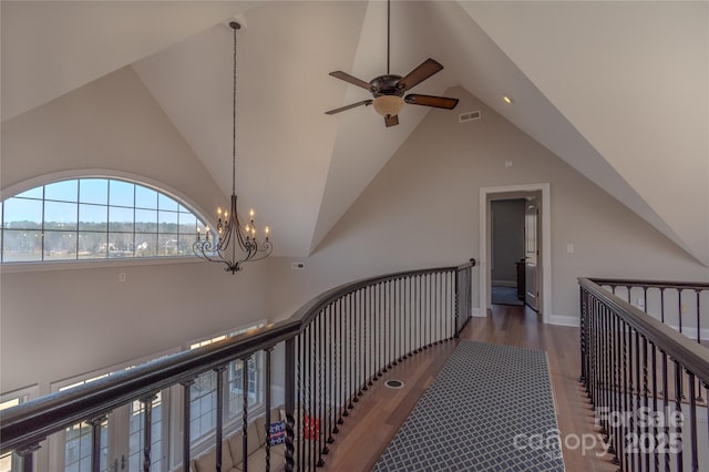 corridor with visible vents, an upstairs landing, an inviting chandelier, and wood finished floors