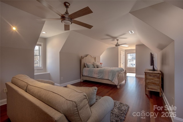 bedroom featuring baseboards, wood finished floors, and vaulted ceiling