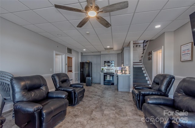 living room featuring visible vents, recessed lighting, a drop ceiling, ceiling fan, and stairs