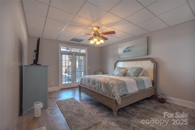 bedroom with access to outside, a paneled ceiling, baseboards, and french doors