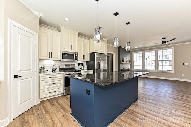 kitchen featuring light wood-style flooring, a center island, stainless steel appliances, crown molding, and backsplash