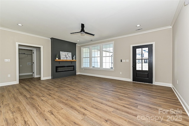 unfurnished living room with crown molding, a fireplace, baseboards, and wood finished floors