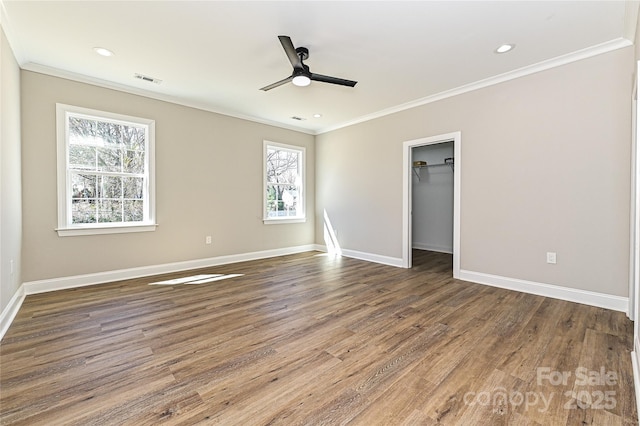 unfurnished bedroom with recessed lighting, crown molding, baseboards, and wood finished floors