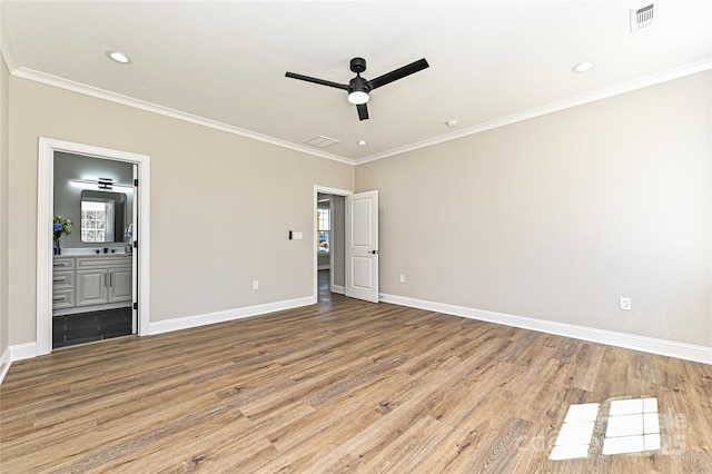 unfurnished bedroom with baseboards, crown molding, visible vents, and wood finished floors