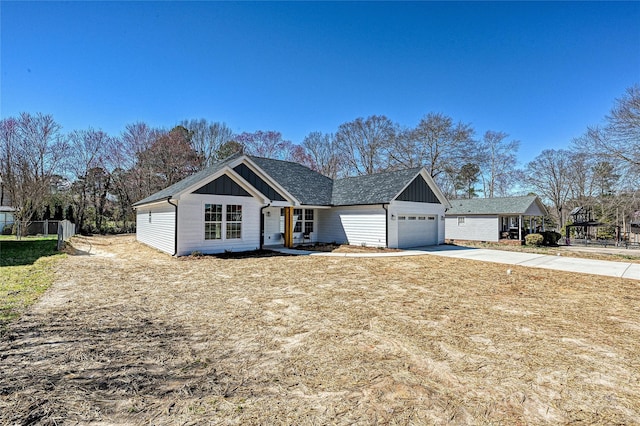 view of front of property featuring concrete driveway, board and batten siding, an attached garage, and fence