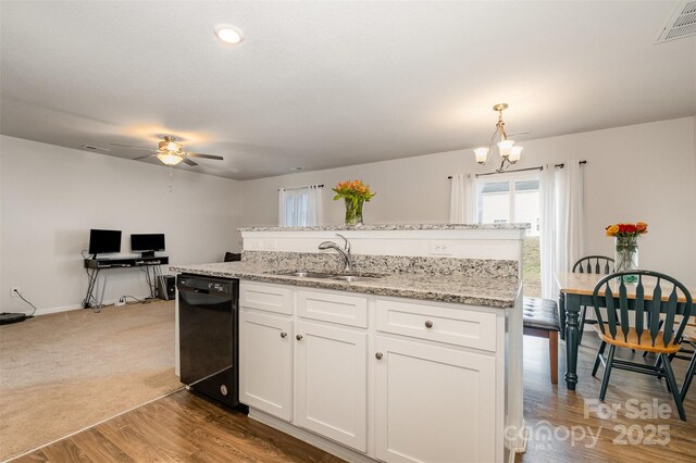 kitchen featuring a sink, visible vents, white cabinetry, black dishwasher, and a center island with sink