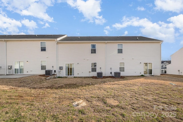 rear view of property featuring a yard and central air condition unit