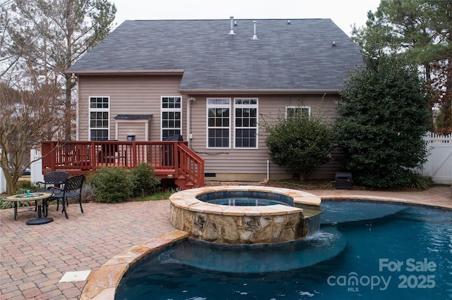 view of swimming pool with a patio area, a pool with connected hot tub, fence, and a deck