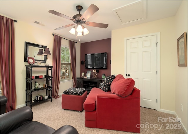 living room featuring attic access, visible vents, baseboards, a ceiling fan, and carpet floors