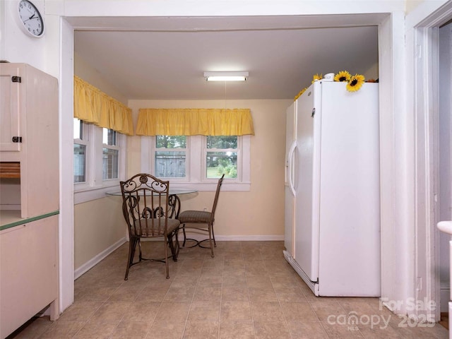 dining room with light tile patterned flooring and baseboards