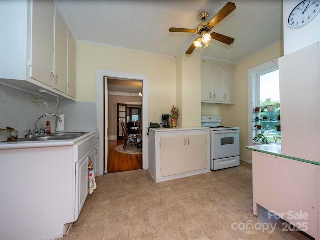 kitchen with white range with electric cooktop, white cabinets, a sink, light countertops, and backsplash