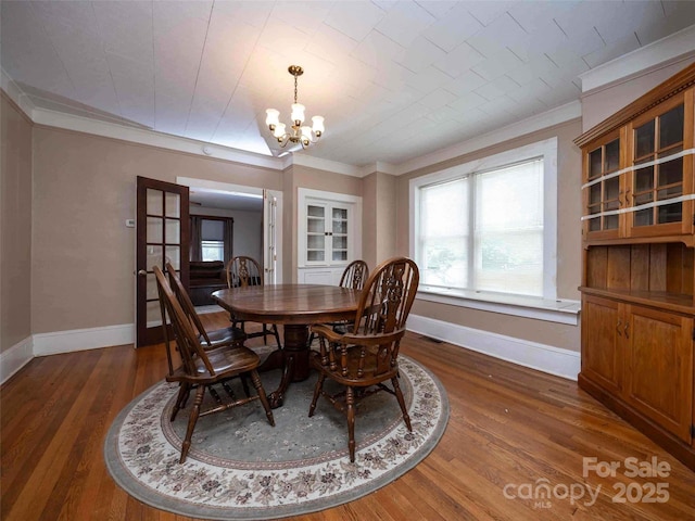 dining area with an inviting chandelier, baseboards, visible vents, and dark wood-type flooring