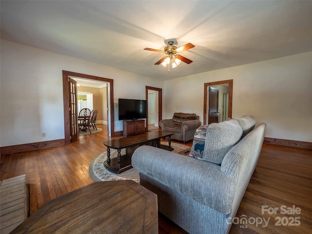 living room featuring ceiling fan, hardwood / wood-style flooring, and baseboards