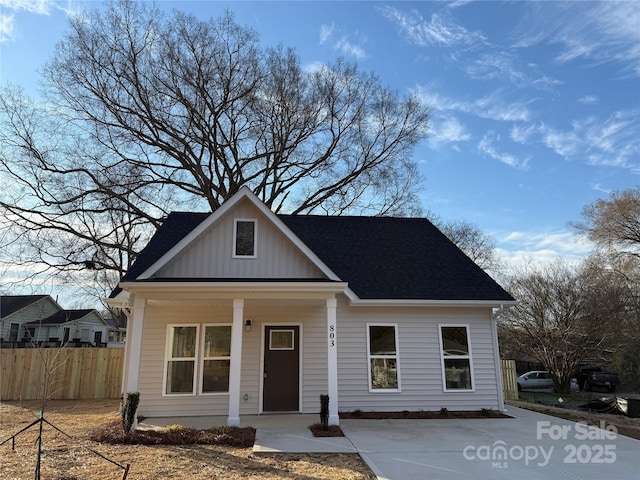 bungalow-style home featuring covered porch, fence, and board and batten siding