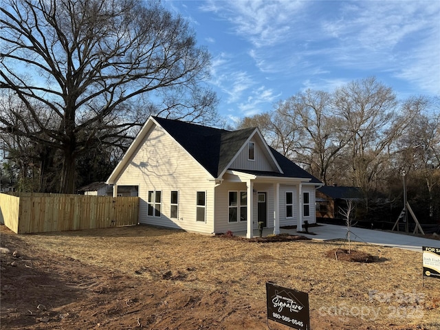 view of front facade featuring a patio area, fence, and board and batten siding