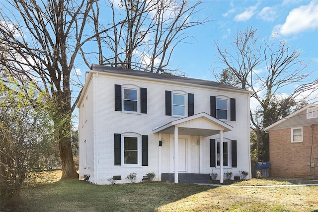 colonial-style house featuring crawl space, brick siding, and a front lawn