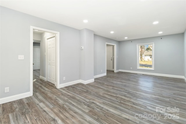 unfurnished room with recessed lighting, baseboards, and wood finished floors