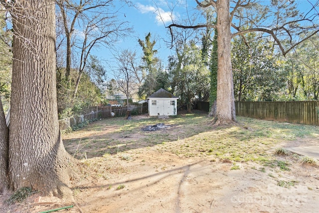 view of yard with an outbuilding, a storage shed, and a fenced backyard